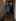 A woman in a raincoat stands in a dim hallway, before the Movie Poster Generator casts her in a horror film.