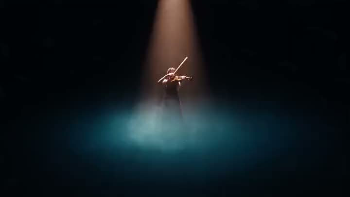 An AI video of a violinist playing alone under a single spotlight on a dark stage, with blue mist pooling at their feet.