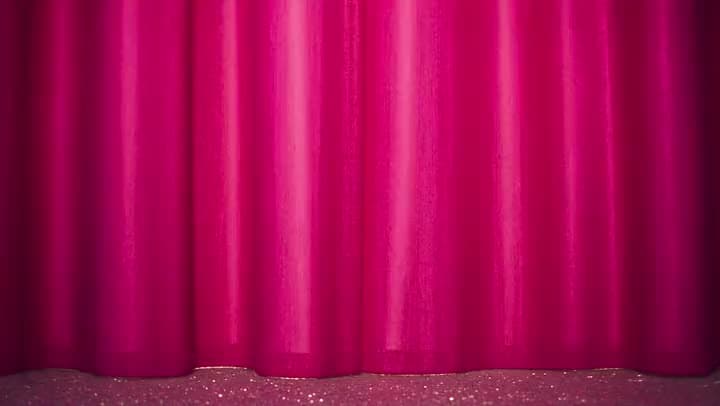 An AI video opening on a closed pink stage curtain above a glittering floor, waiting for the performance to begin.