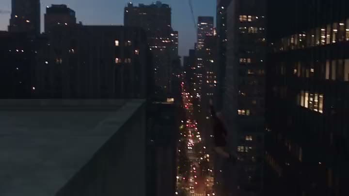 An AI video of a figure swinging down between skyscrapers at dusk above a street lined with glowing traffic lights.