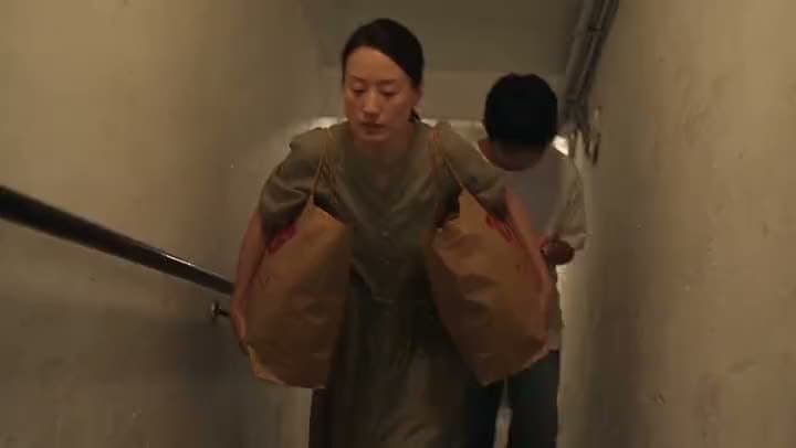 An AI video of a woman carrying two heavy paper shopping bags up a narrow stairwell as a boy follows behind her.
