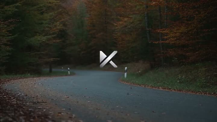 An AI car ad opening on a silver logo over an empty, winding road through an autumn forest.