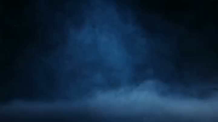An AI product ad opening on blue smoke drifting low across a dark, empty stage before the product appears.