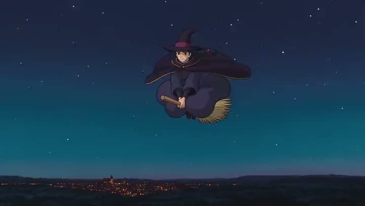 An AI anime clip of a young witch in a pointed hat and dark cloak flying a broomstick through a starry sky above a lit town.